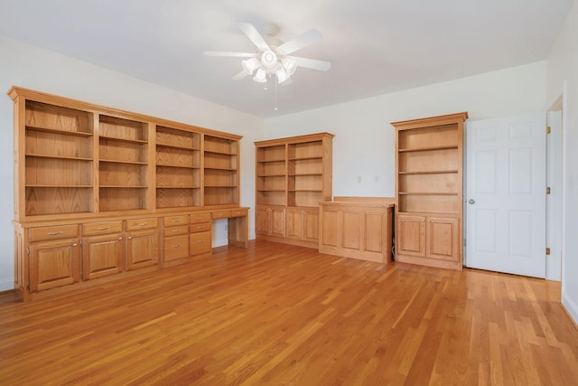 interior space with light wood-type flooring, built in desk, and ceiling fan