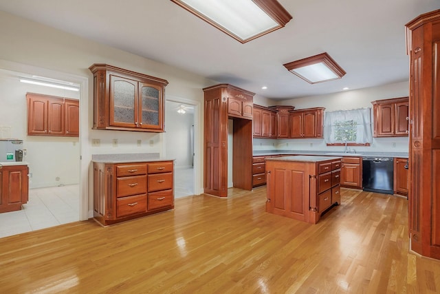 kitchen with a center island, light hardwood / wood-style flooring, sink, and black dishwasher