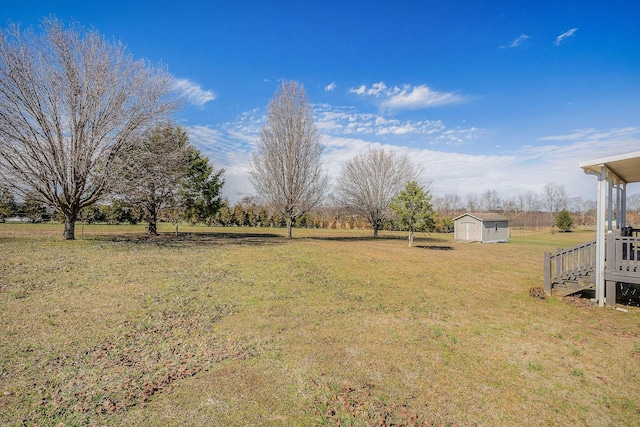 view of yard featuring a rural view and a storage shed