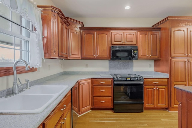 kitchen with light hardwood / wood-style floors, sink, and black appliances