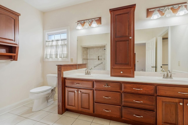 bathroom with tile patterned flooring, vanity, toilet, and tiled shower