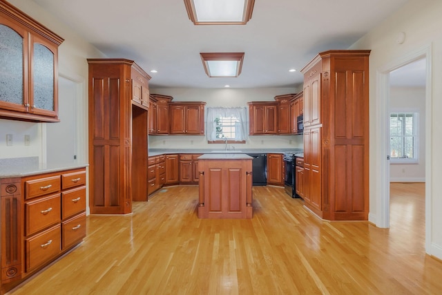 kitchen with light hardwood / wood-style flooring, electric stove, dishwasher, a center island, and sink