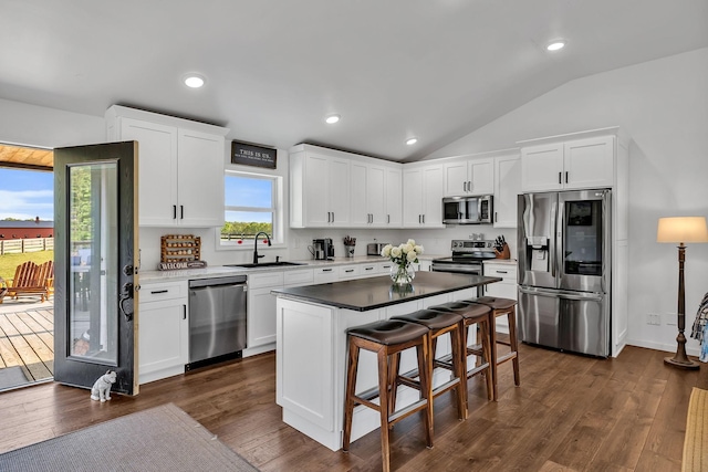 kitchen featuring appliances with stainless steel finishes, sink, white cabinets, and a center island