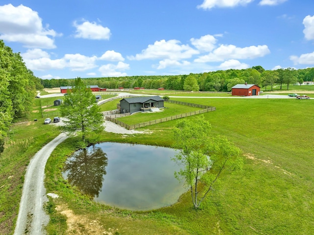 surrounding community with a water view, an outdoor structure, and a lawn