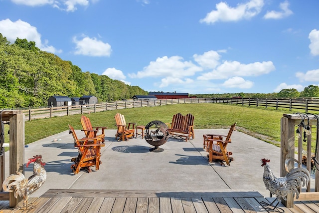 view of patio with a rural view, a deck, and a fire pit