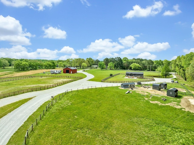 view of home's community featuring an outbuilding, a rural view, and a yard