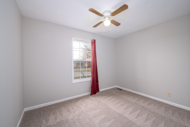 unfurnished room featuring ceiling fan, carpet flooring, visible vents, and baseboards