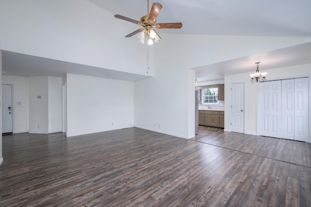 unfurnished living room featuring baseboards, dark wood-style floors, high vaulted ceiling, a sink, and ceiling fan with notable chandelier