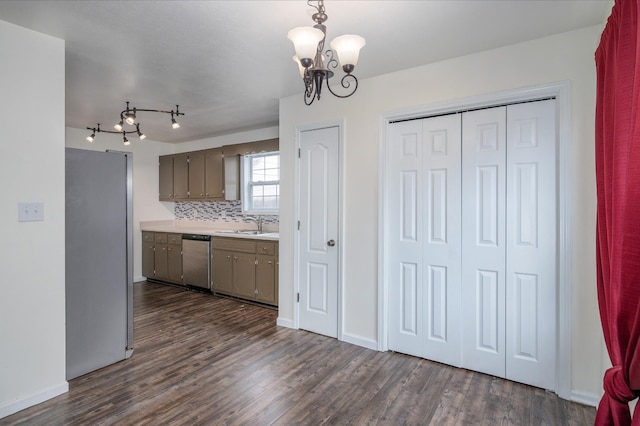 kitchen with stainless steel appliances, dark wood-style flooring, light countertops, and backsplash