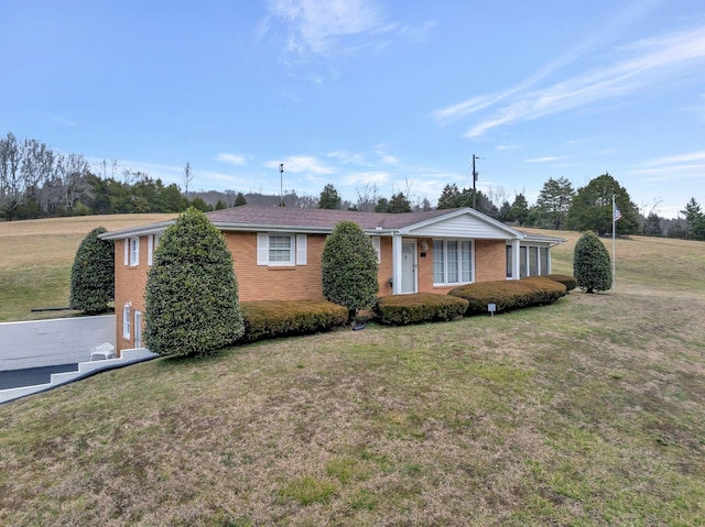 ranch-style home featuring a front lawn and brick siding