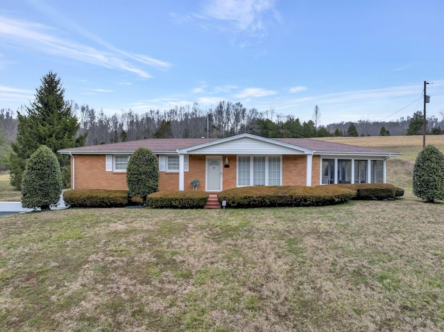 single story home with brick siding and a front yard