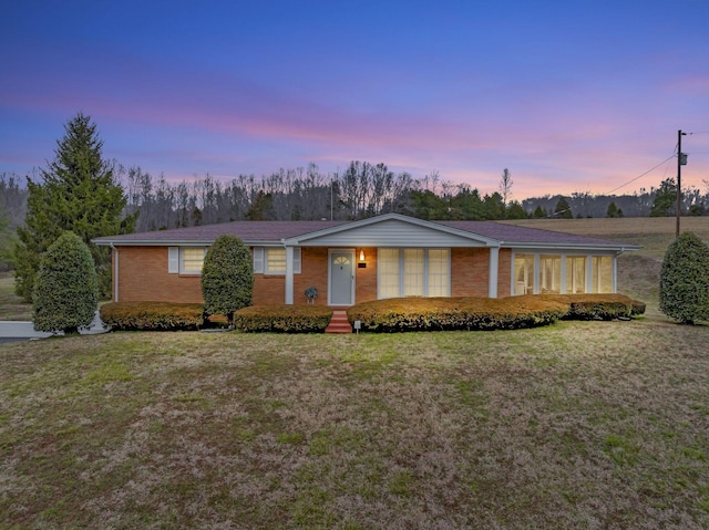 view of front of property featuring brick siding and a front lawn