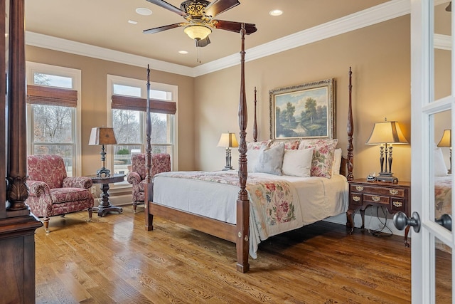 bedroom with ceiling fan, wood-type flooring, and ornamental molding