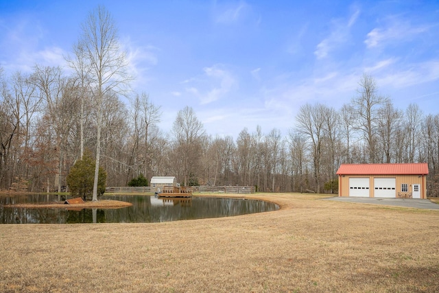 view of yard with a water view, an outdoor structure, and a garage