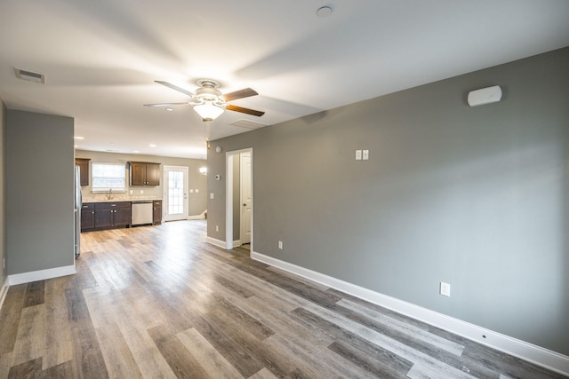 unfurnished living room with sink, hardwood / wood-style flooring, and ceiling fan