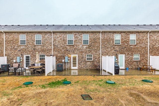 back of property featuring a patio area, a lawn, and central AC unit