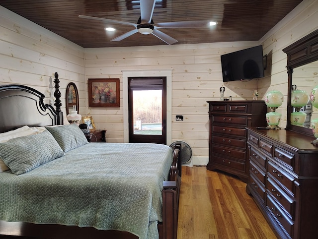 bedroom with wooden ceiling, wood walls, and light hardwood / wood-style floors