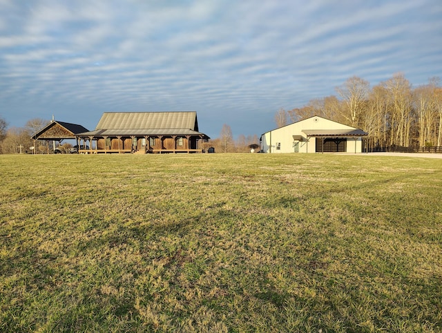 view of yard featuring a garage, a pole building, and an outdoor structure