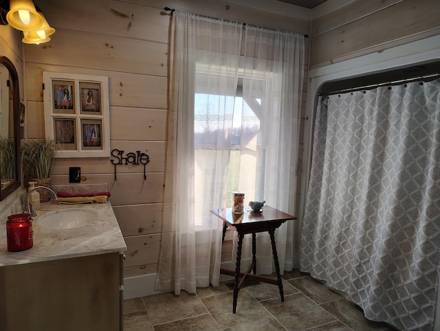 bathroom with vanity, a shower with shower curtain, and wood walls