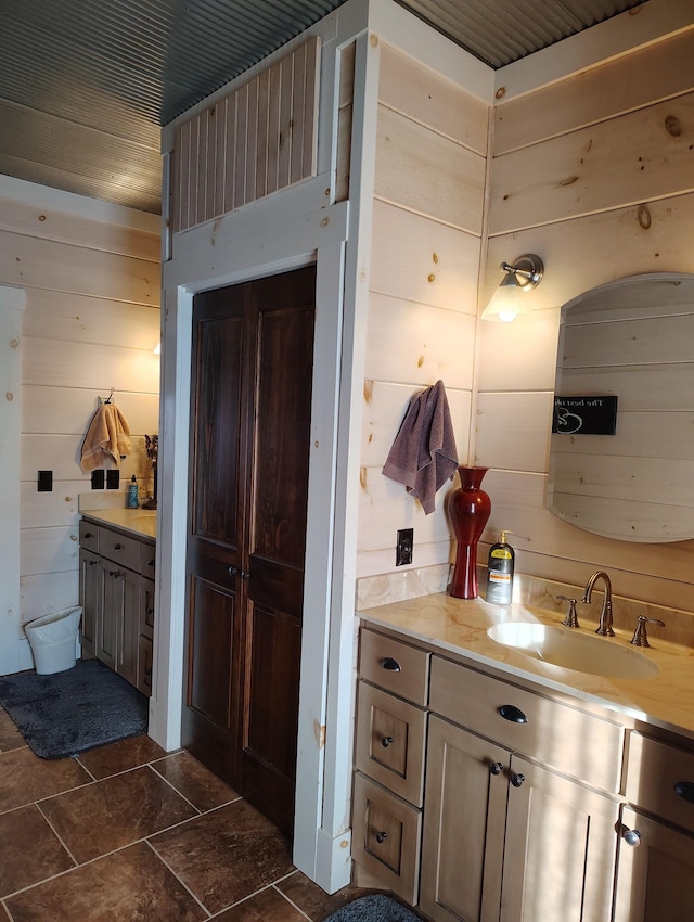 bathroom featuring vanity and wooden walls