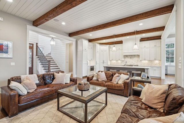 living area with stairs, beamed ceiling, and recessed lighting