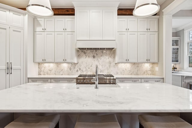 kitchen with white cabinetry, light stone countertops, and a kitchen breakfast bar