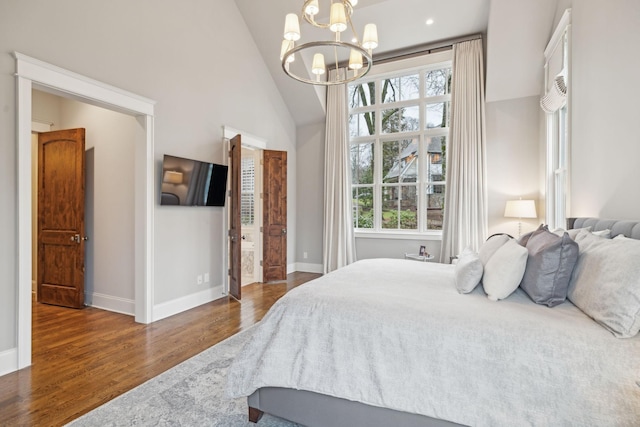 bedroom featuring high vaulted ceiling, dark wood-style flooring, a chandelier, and baseboards