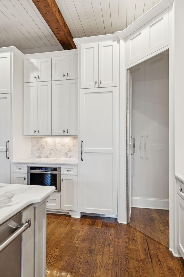 kitchen featuring tasteful backsplash, white cabinetry, dark wood finished floors, and beamed ceiling