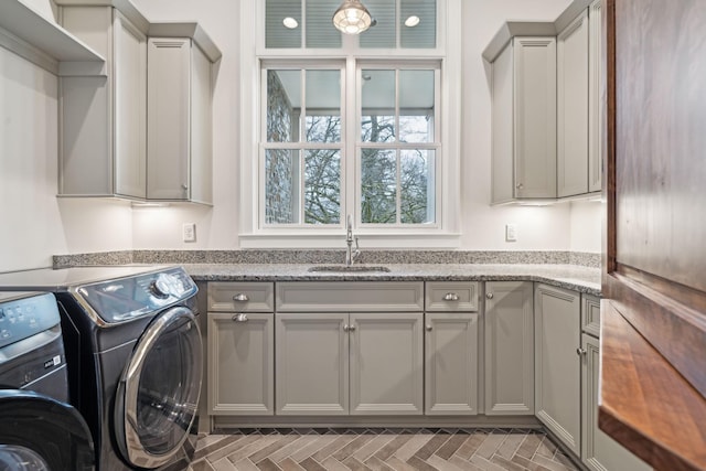 laundry room featuring independent washer and dryer, cabinet space, and a sink