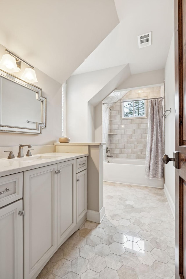 bathroom with shower / bath combo, vanity, visible vents, and baseboards