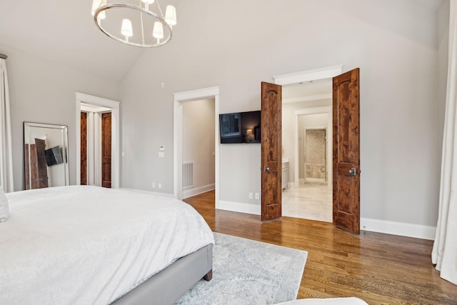 bedroom featuring baseboards, visible vents, dark wood-style flooring, ensuite bathroom, and an inviting chandelier