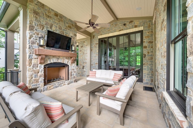 view of patio with ceiling fan and an outdoor living space with a fireplace