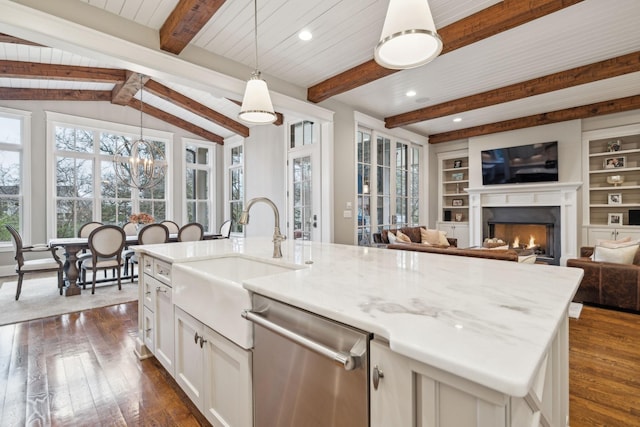 kitchen featuring open floor plan, dishwasher, an island with sink, dark wood finished floors, and decorative light fixtures