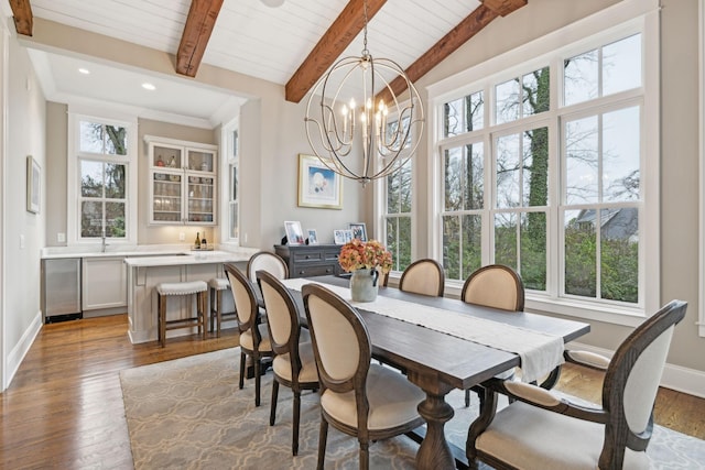 dining area with baseboards, plenty of natural light, beam ceiling, and an inviting chandelier