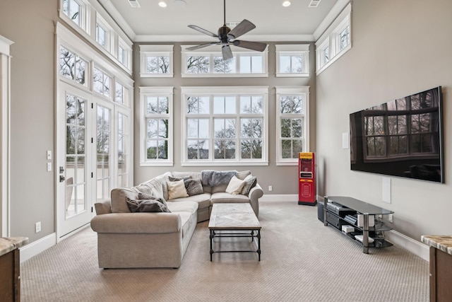 carpeted living room featuring a ceiling fan, recessed lighting, a towering ceiling, and baseboards