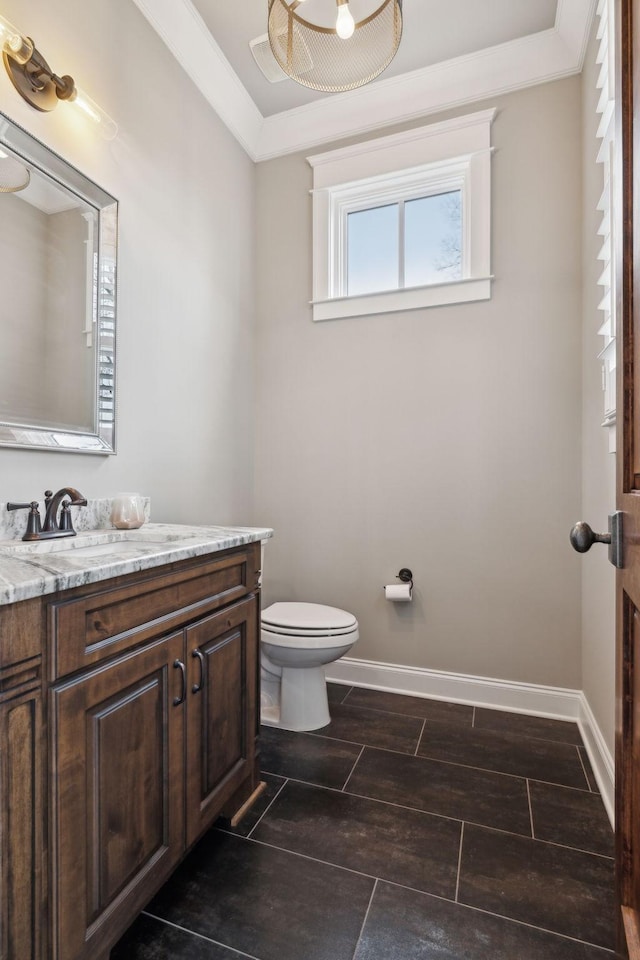 bathroom featuring toilet, vanity, baseboards, ornamental molding, and wood tiled floor