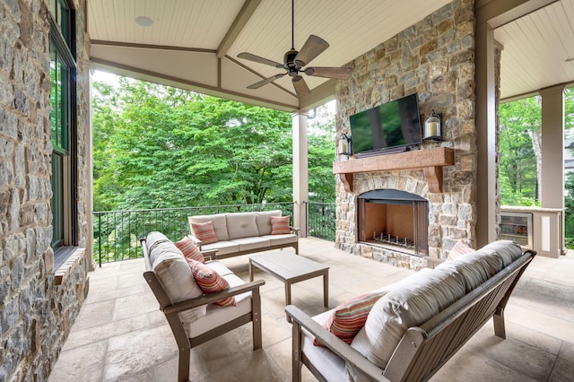 view of patio with an outdoor living space with a fireplace and a ceiling fan