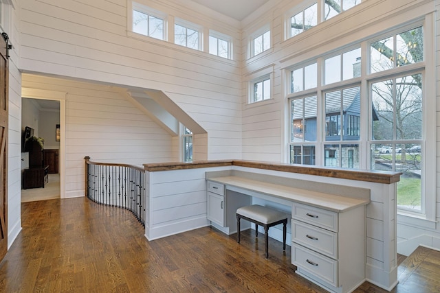 home office with dark wood-type flooring and built in study area