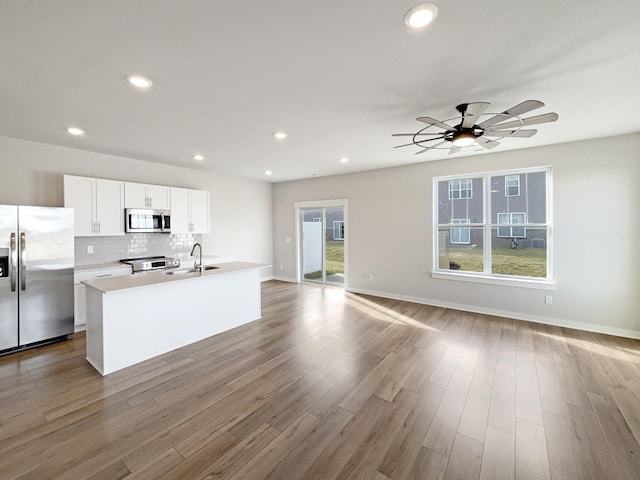 kitchen featuring a sink, white cabinetry, light countertops, appliances with stainless steel finishes, and an island with sink