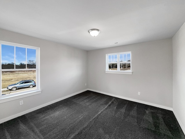 unfurnished room featuring carpet and baseboards