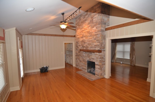 unfurnished living room with a fireplace, lofted ceiling, hardwood / wood-style floors, and ceiling fan