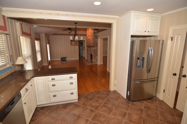 kitchen featuring appliances with stainless steel finishes, dark tile patterned flooring, decorative light fixtures, crown molding, and white cabinetry