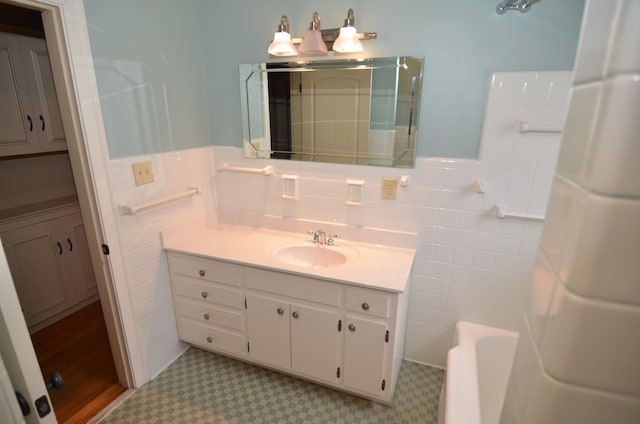 bathroom featuring tile walls, independent shower and bath, and vanity