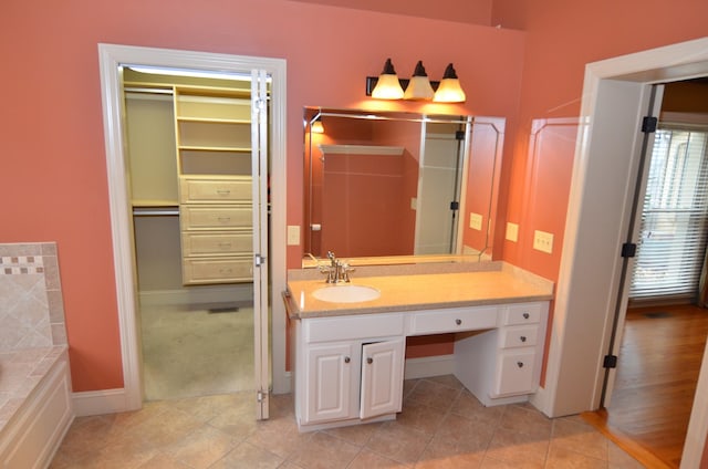 bathroom featuring tile patterned floors, vanity, and a bathing tub