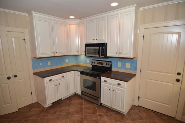 kitchen featuring white cabinets, appliances with stainless steel finishes, dark tile patterned flooring, and tasteful backsplash