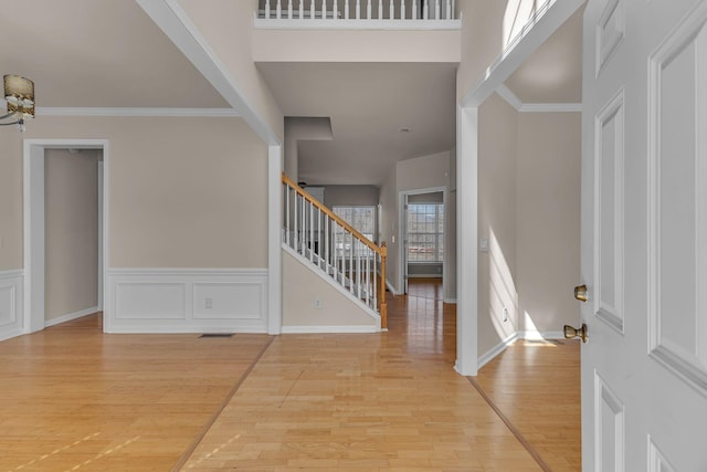 9746 Northfork Dr, Brentwood, TN 37027 - foyer entrance featuring wainscoting, light wood-style flooring, stairs, crown molding, and a decorative wall