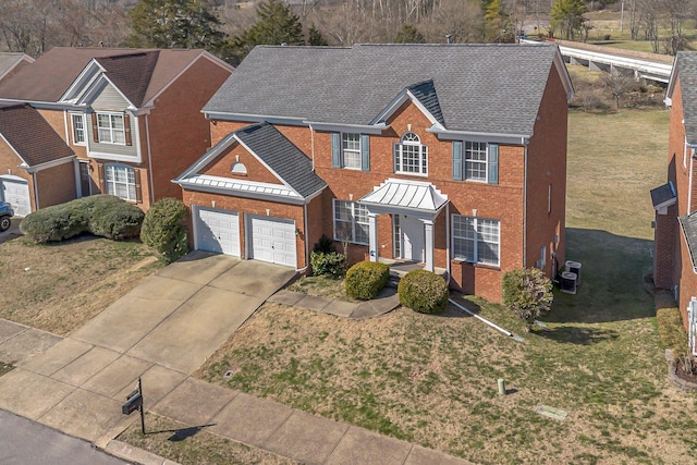 view of front of house featuring an attached garage, brick siding, driveway, roof with shingles, and a front yard