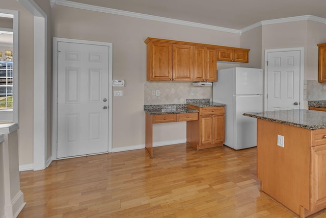9746 Northfork Dr, Brentwood, TN 37027 - kitchen with light wood-style floors, brown cabinetry, crown molding, and freestanding refrigerator