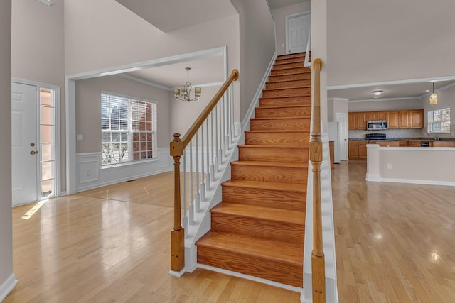 9746 Northfork Dr, Brentwood, TN 37027 - entrance foyer featuring a wainscoted wall, a high ceiling, stairway, and light wood-style floors
