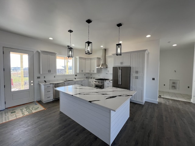 kitchen featuring white cabinets, a kitchen island, high quality appliances, and wall chimney exhaust hood